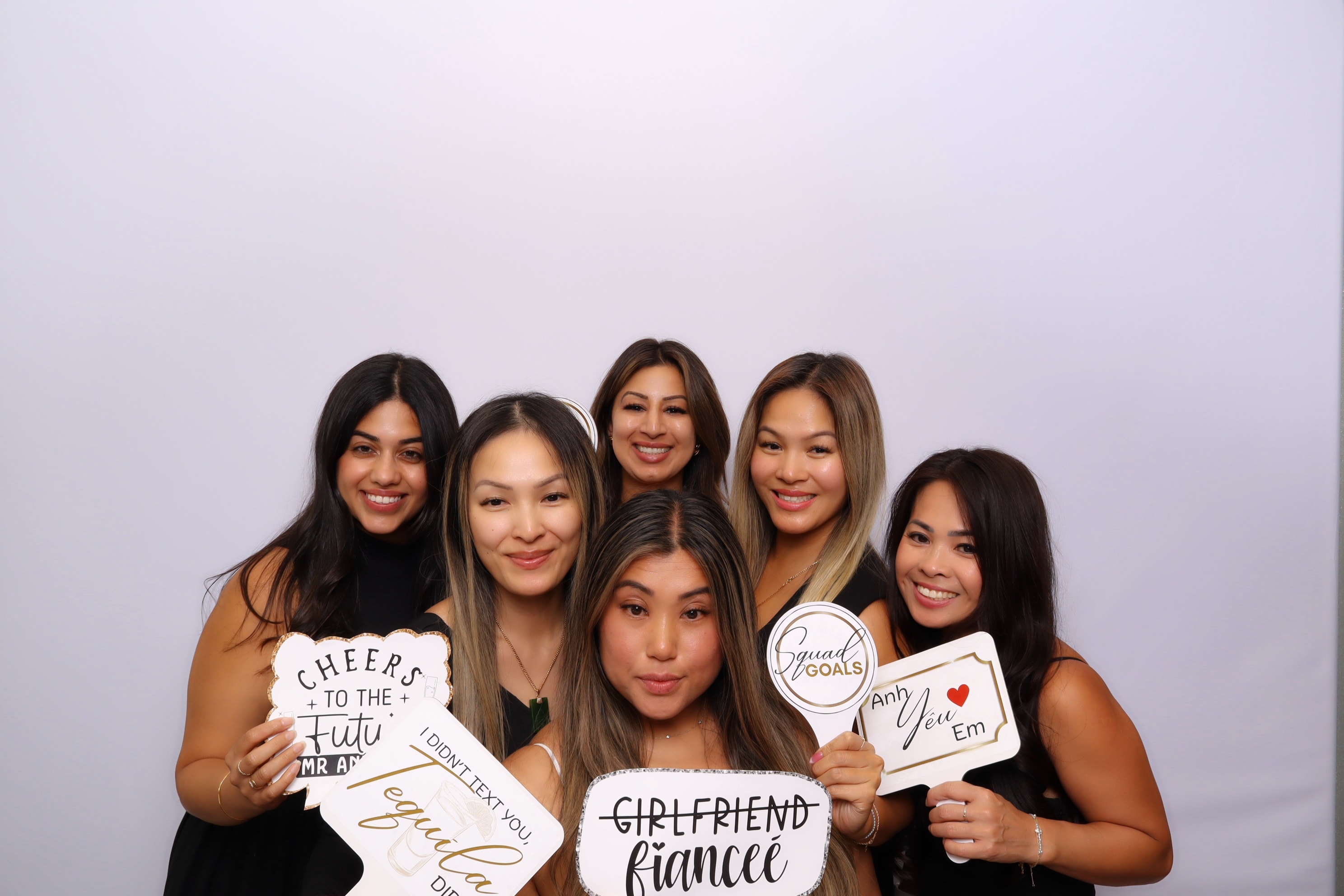 Friends posing with wedding photo booth props