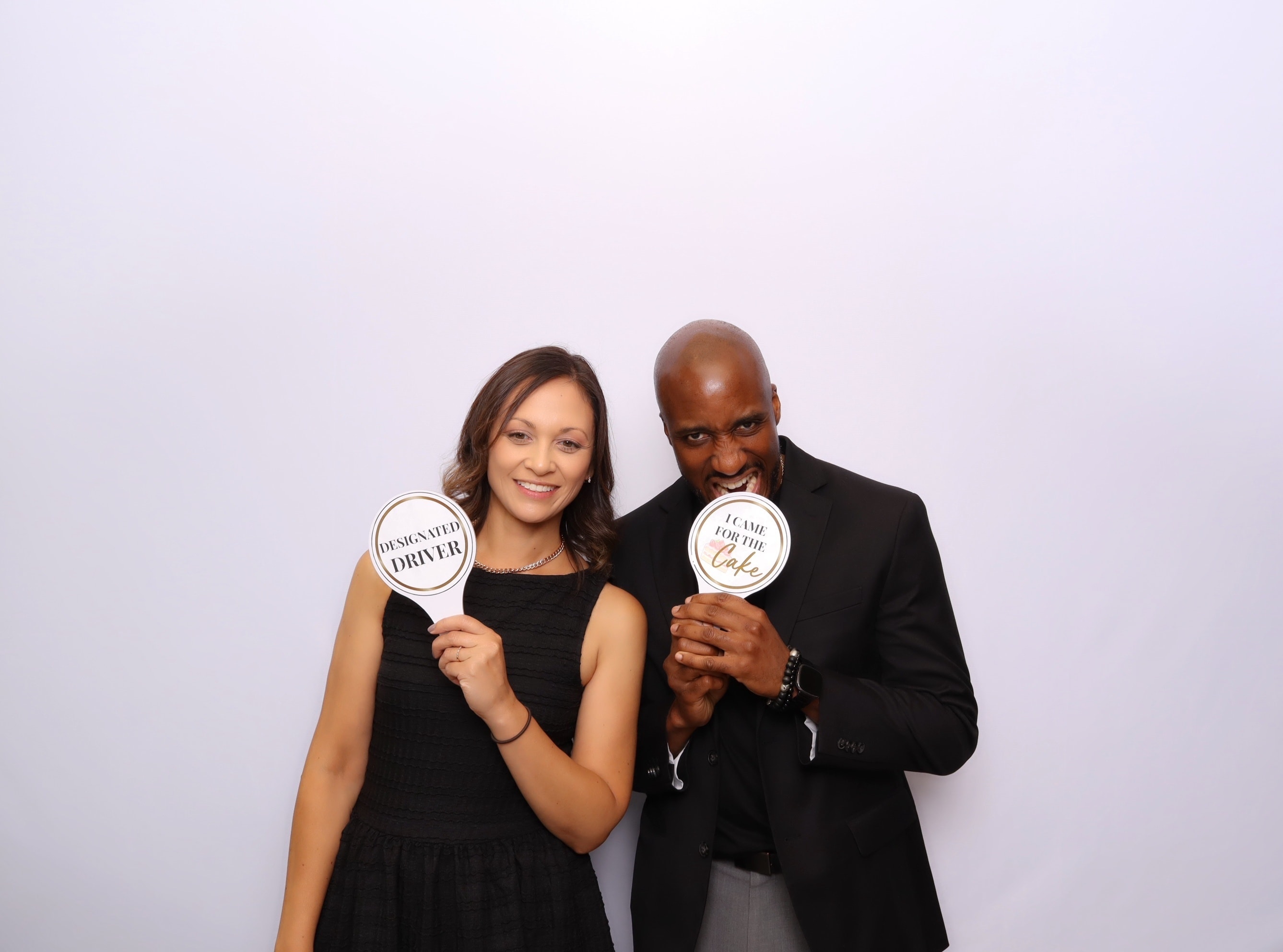 Couple celebrating with photo booth signs