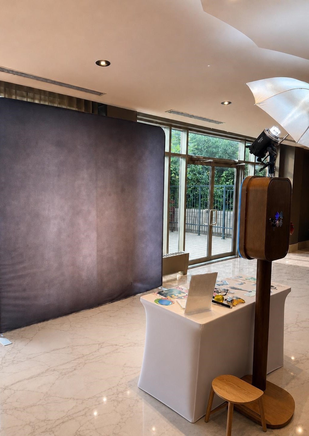 Open air photo booth with white floral wall at luxury wedding
